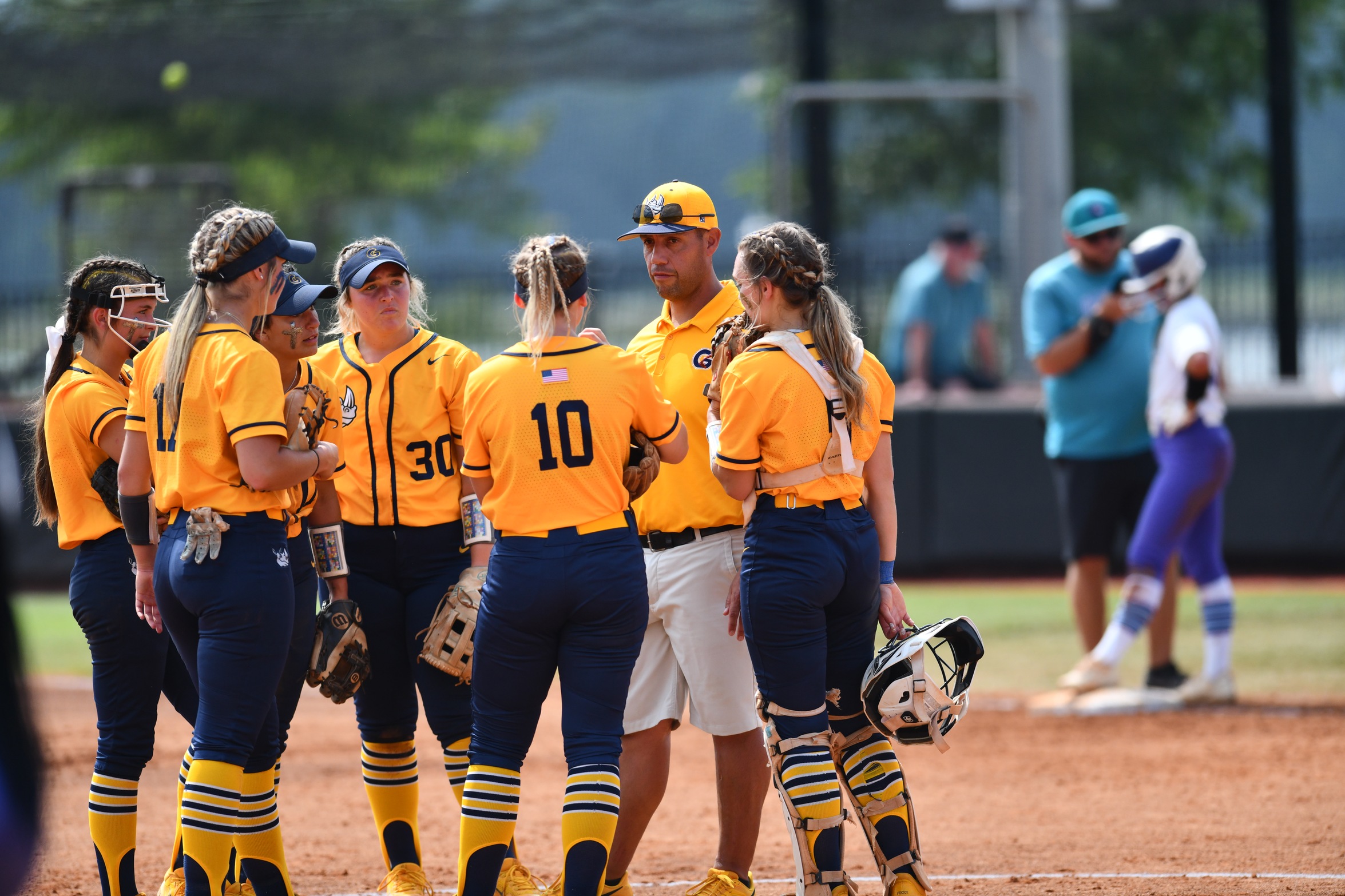 Gaston College head coach Mike Steuerwald (2nd from right) holds a pitcher's mound visit during the Rhinos' appearance in the 2023 NJCAA World Series in Oxford, Ala.